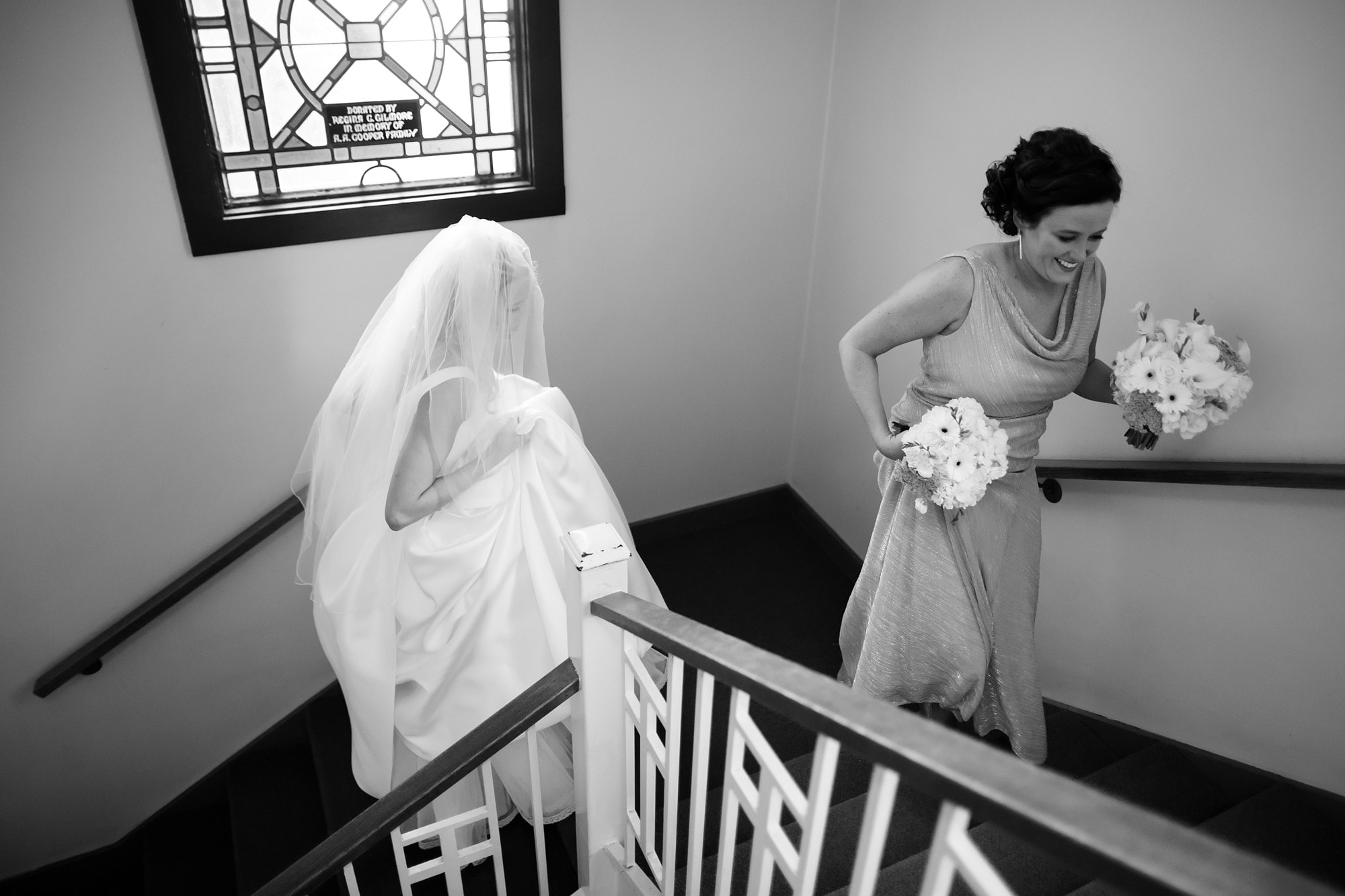 Bride Shannon walks up the stairs at Cathedral of Saint Raphael