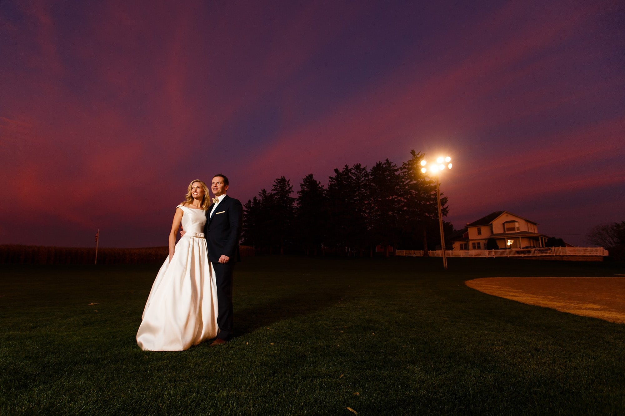 The sun sets as Shannon and David pose at the during their Field of Dreams wedding in Dyersville, Iowa