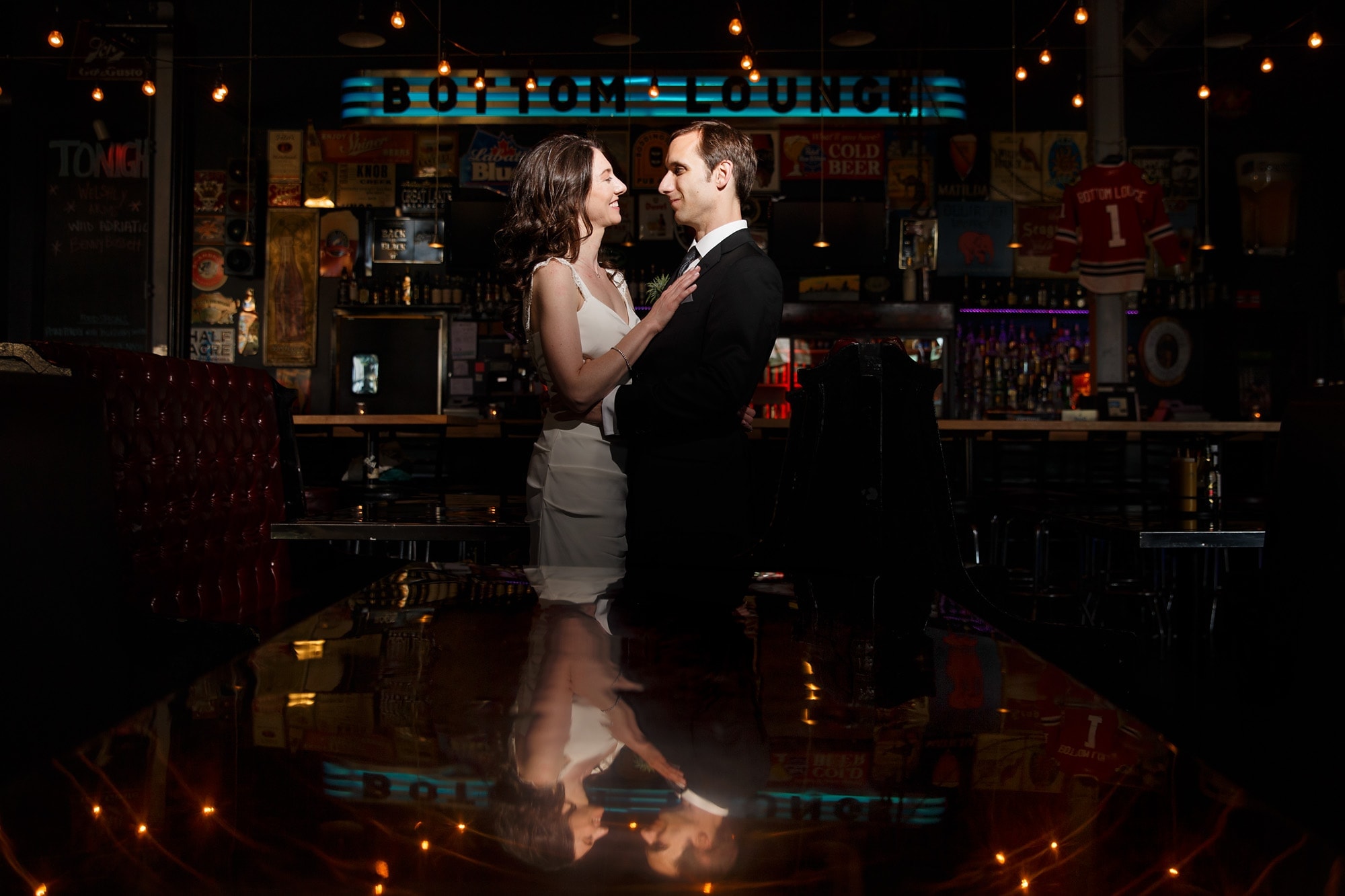A couple staring into each others eyes are reflected into a table inside Bottom Lounge after their wedding in Chicago, Illinois.