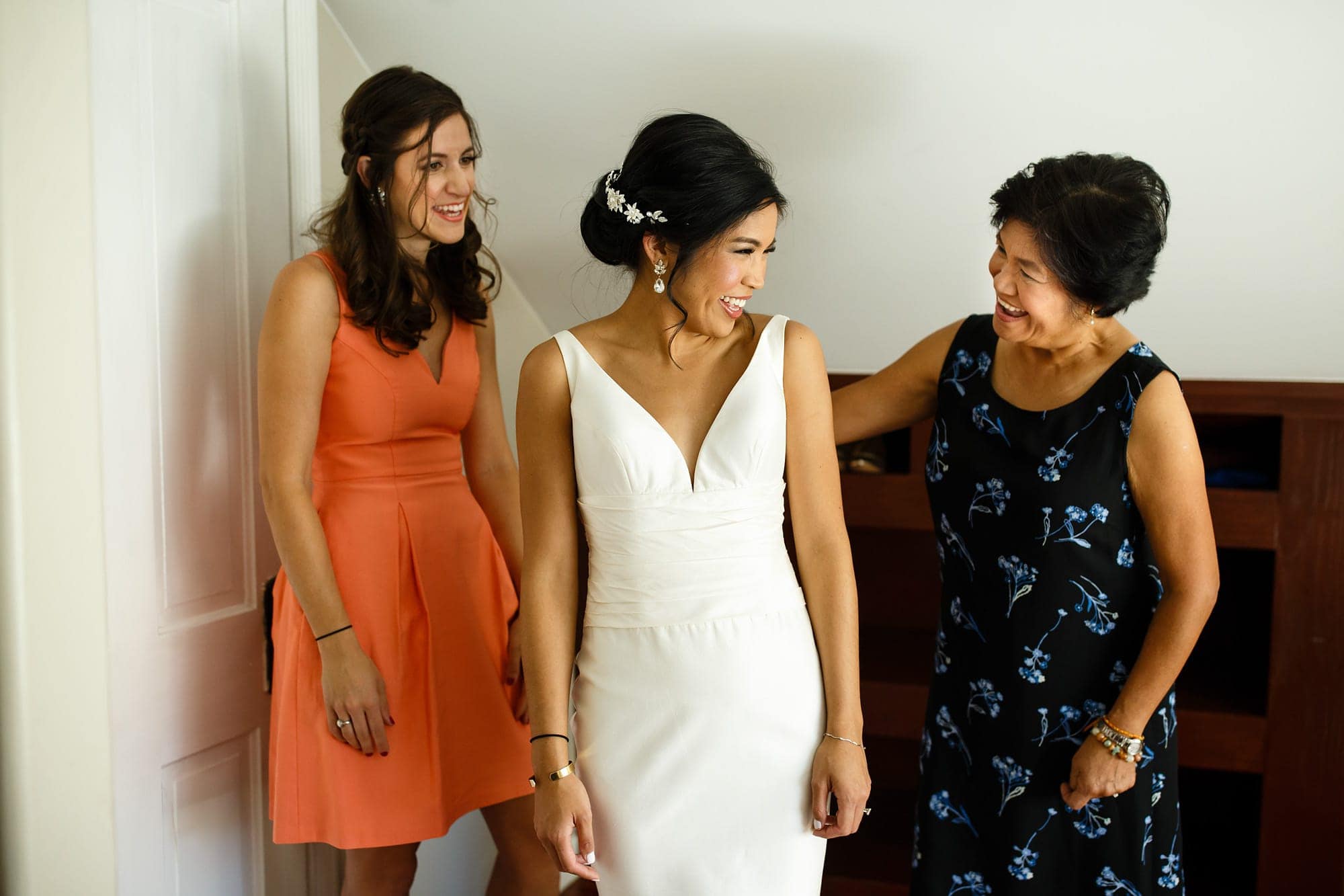 Megan shares a laugh with her mother while getting dressed with her maid of honor before her wedding in Boulder at Rembrandt Yard