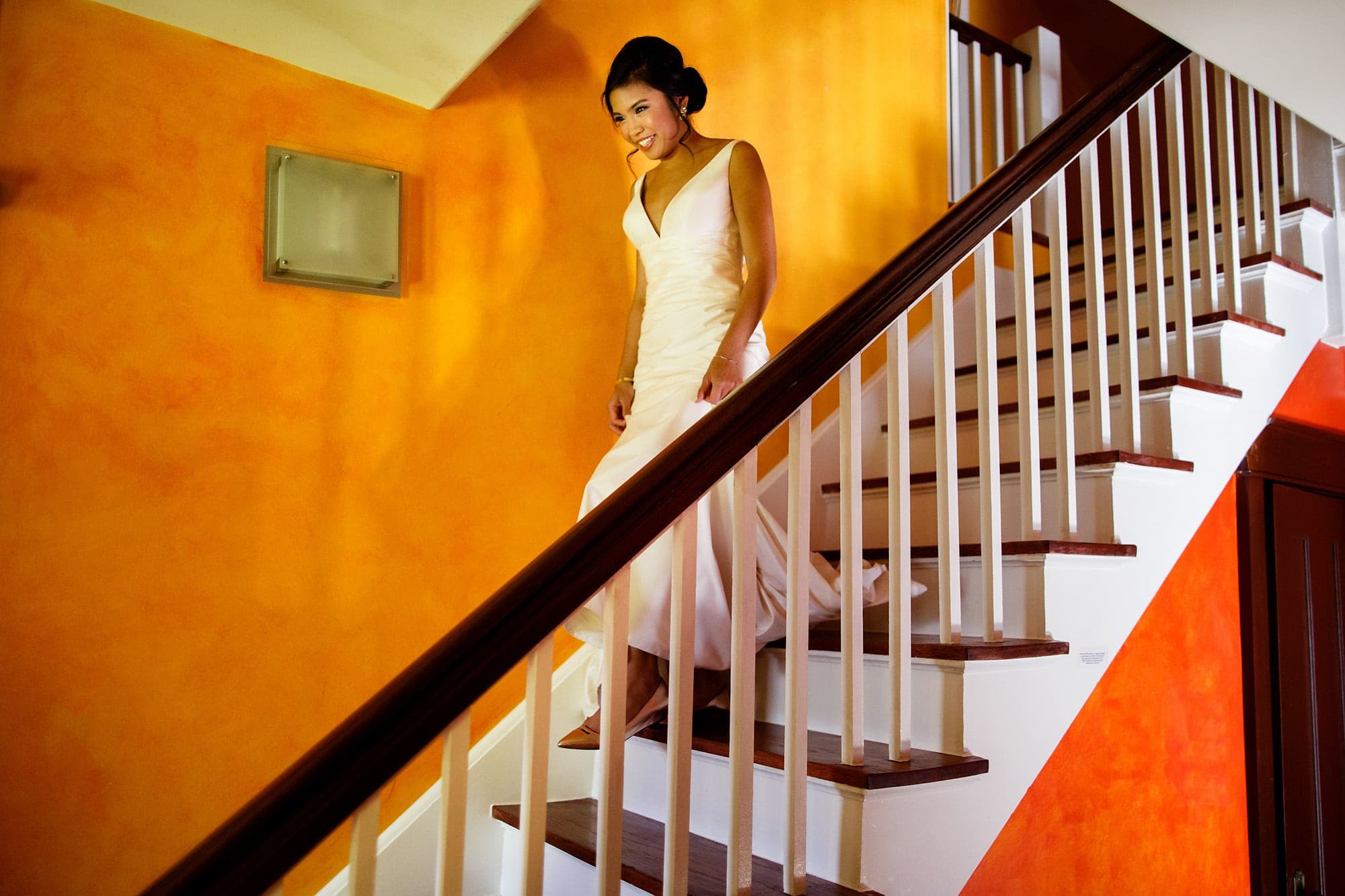 Megan walks down the stairs for the first time in her wedding dress at an Air BnB home in Boulder