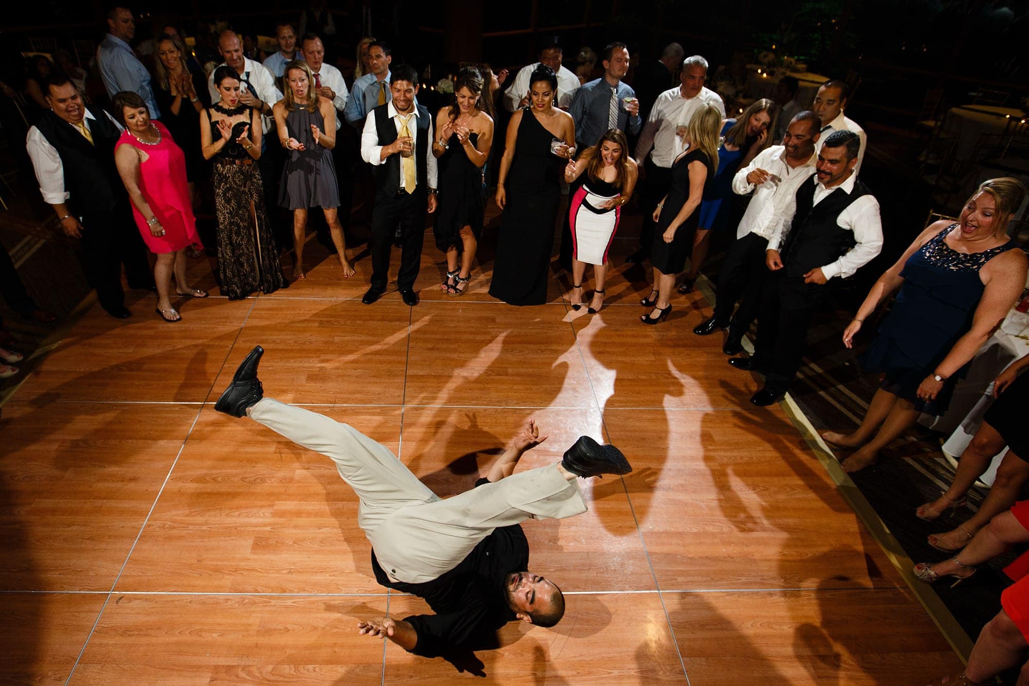 A guest break dances on the dance floor during the wedding reception at The Hyatt Lodge in Oak Brook, Illinois.