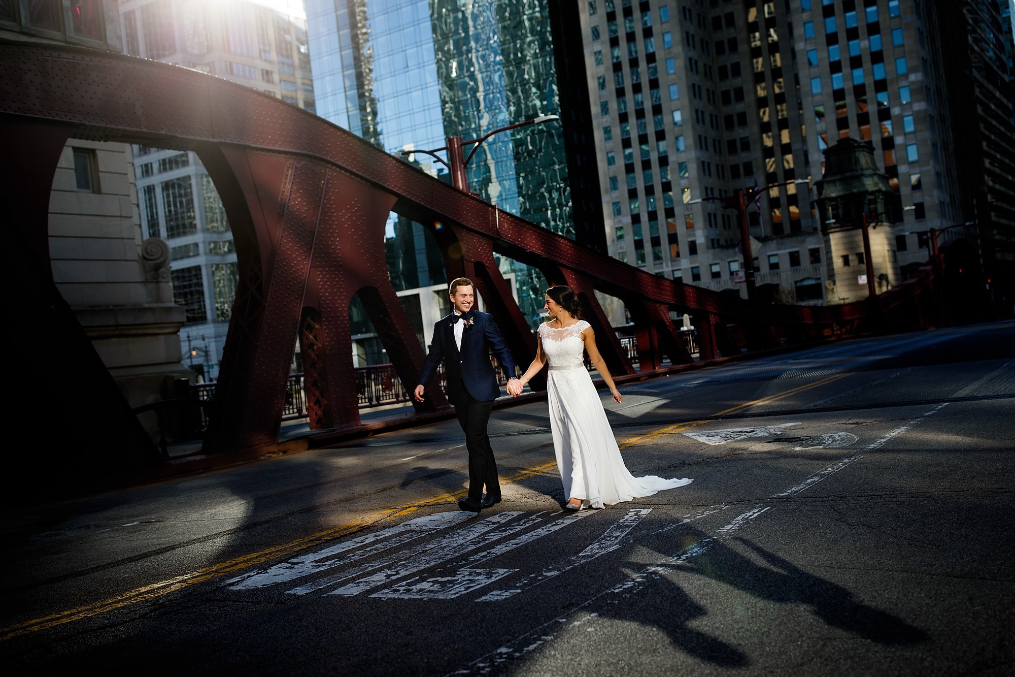 A couple walk hand in hand on the LaSalle Street Bridge in Chicago on a warm November day.