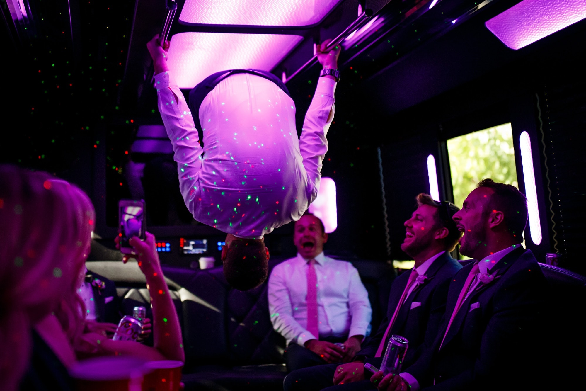 A groomsmen does a flip inside a bus on the way to a wedding reception for Kara and Matt in Chicago.