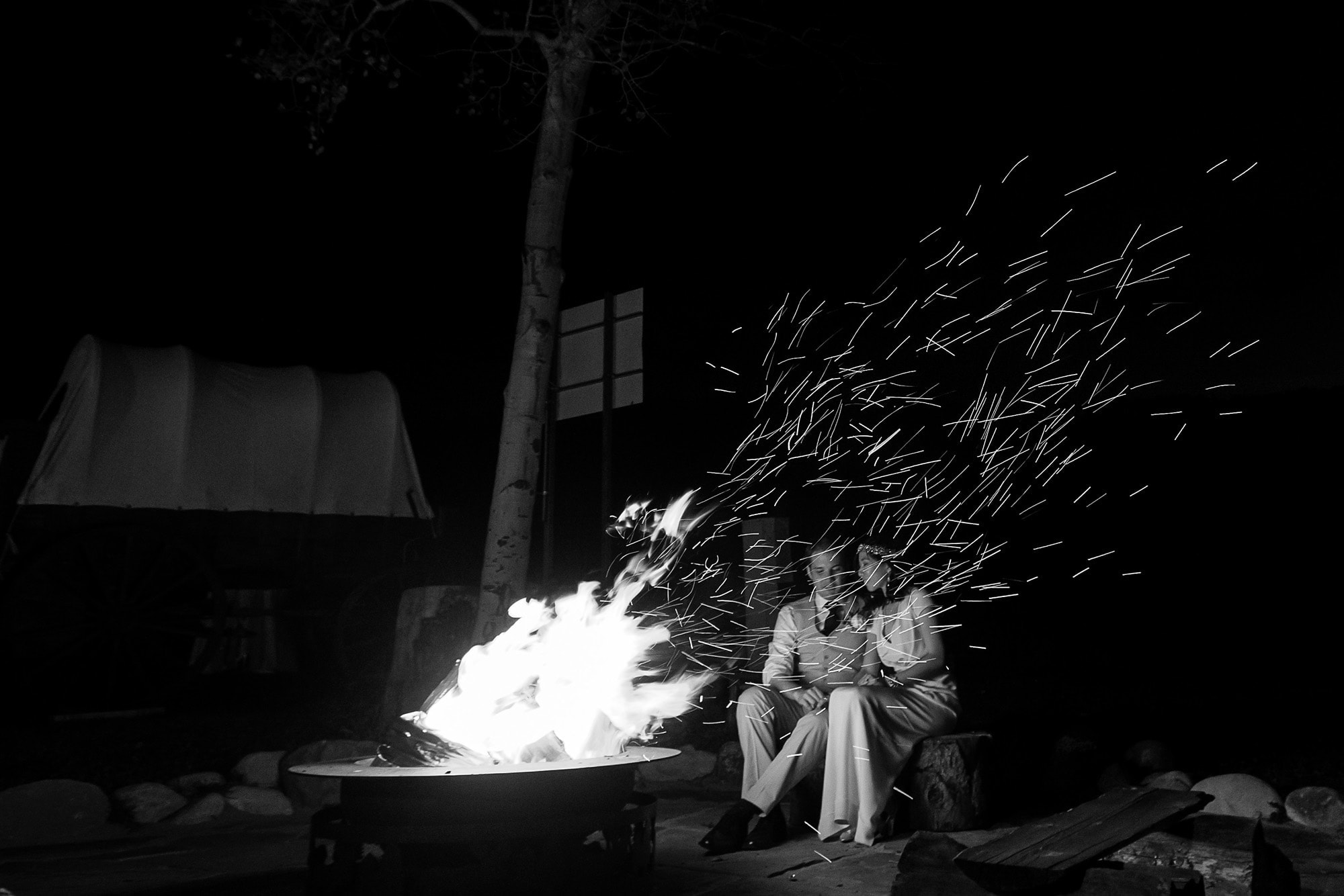 Walker and Allison sit by the fire at Lynn Britt Cabin during their wedding in Snowmass Village near Aspen, Colorado.