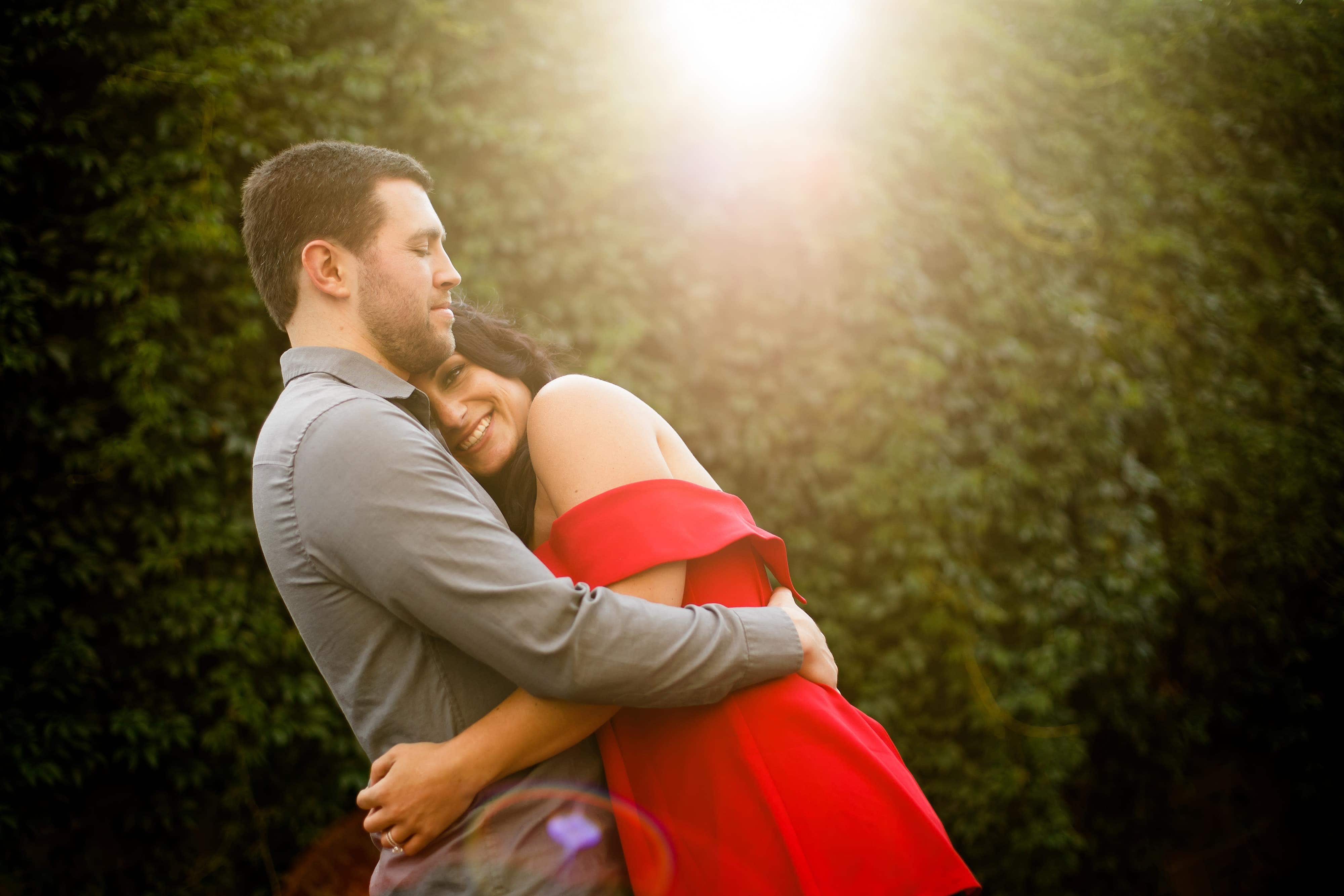 The sun flares in past a smiling Danielle and Jordan during their engagement session in Denver