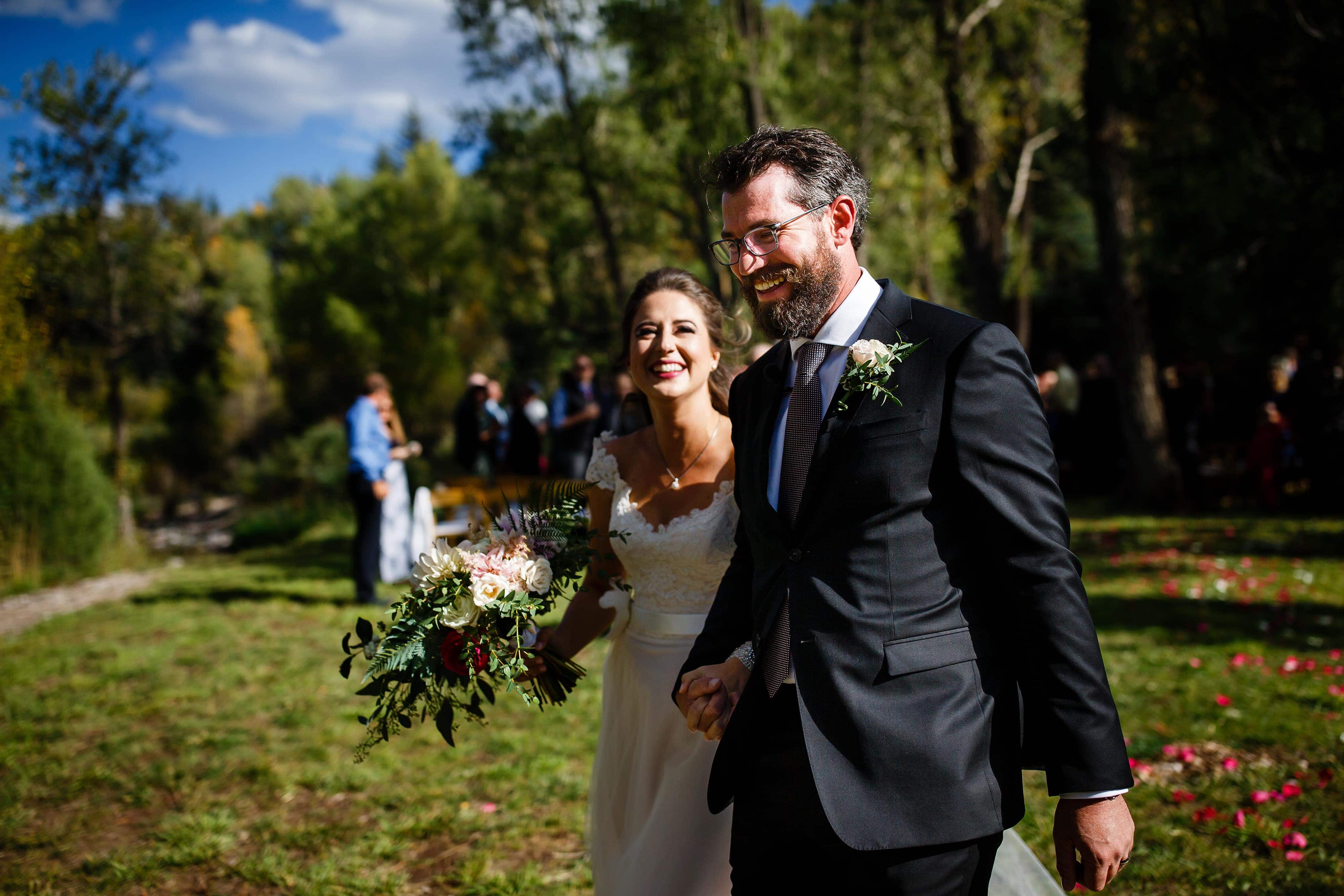 Mallory and Daniel celebrate as husband and wife after their fall Snowmass Cottages wedding