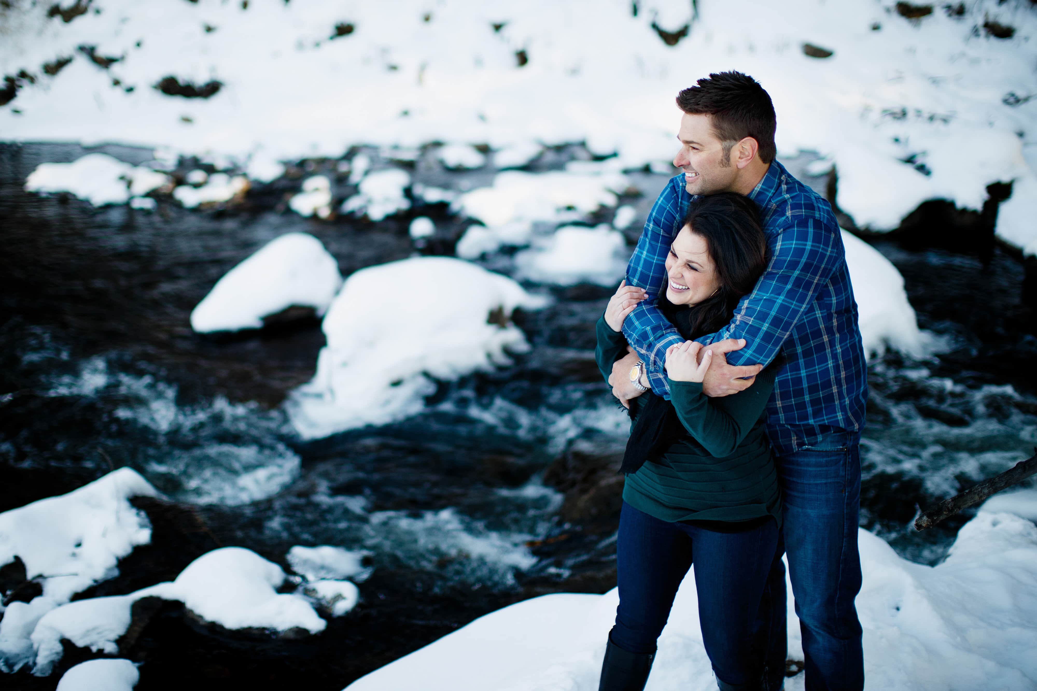 Jordan keeps Melissa warm near the snow bank of the Bear Creek in Evergreen