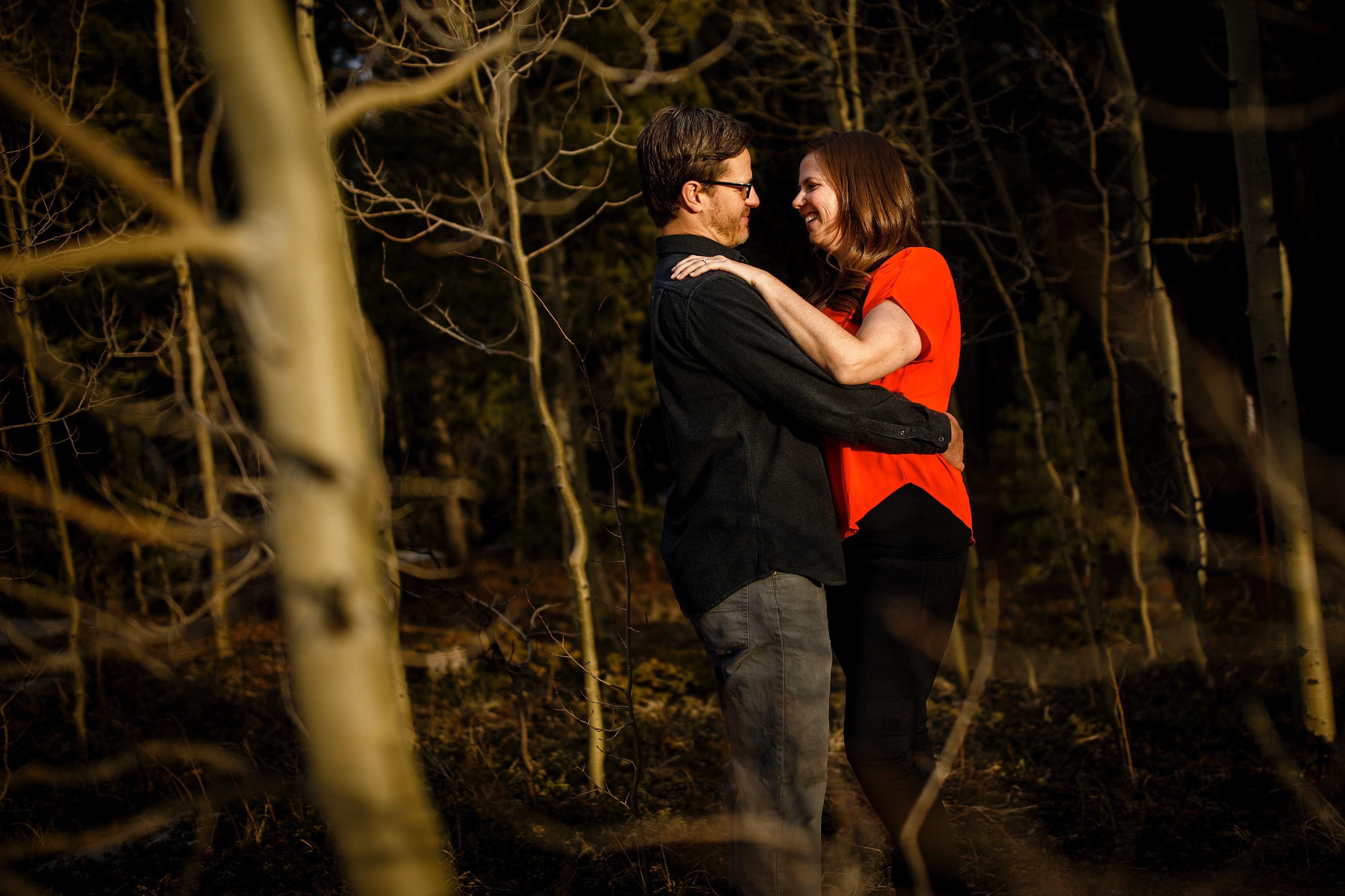 Brian and Kate embrace in a grove of aspens during their spring engagement session near Golden Gate Canyon State Park