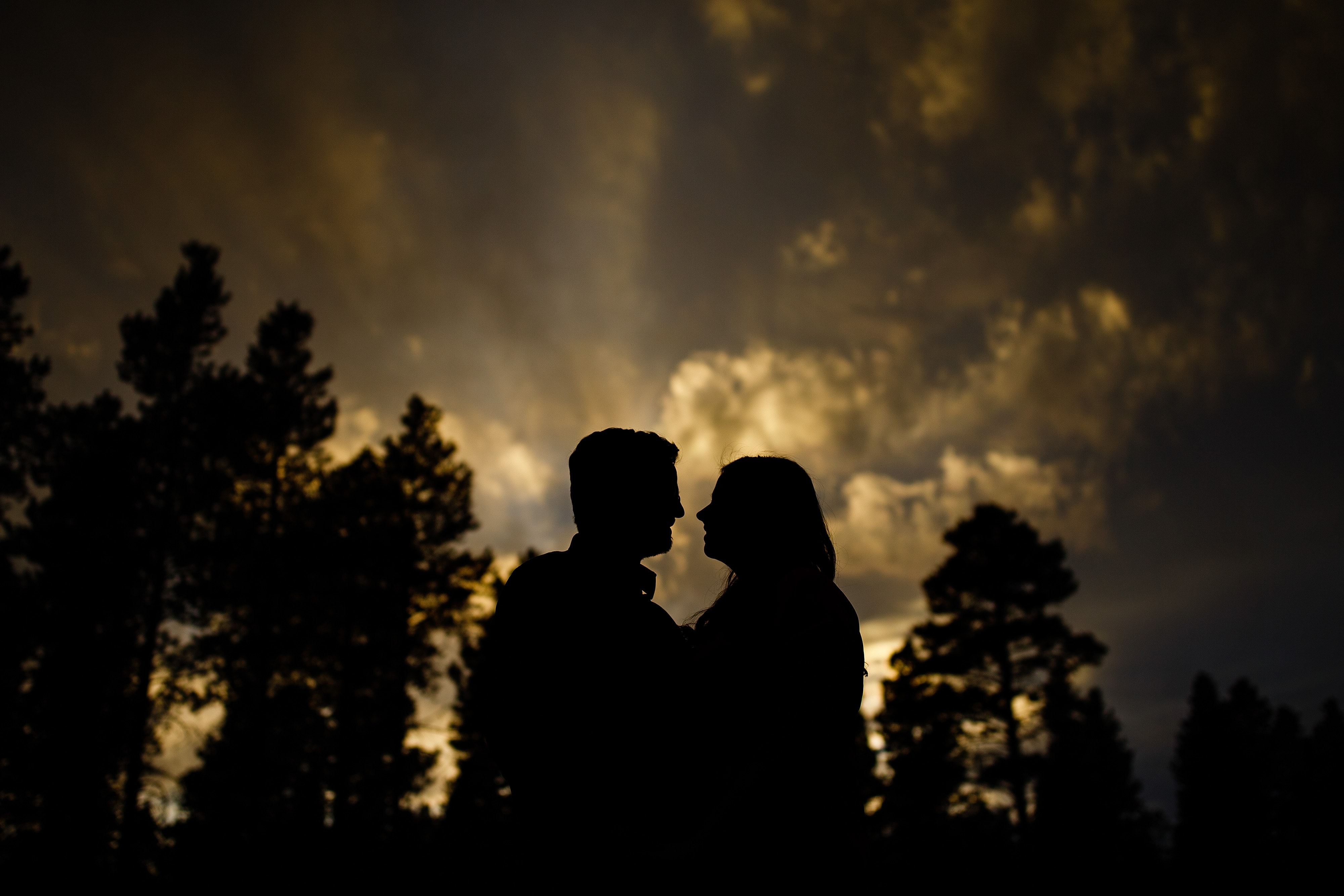 Brian and Kate are silhouetted against the sessting sky