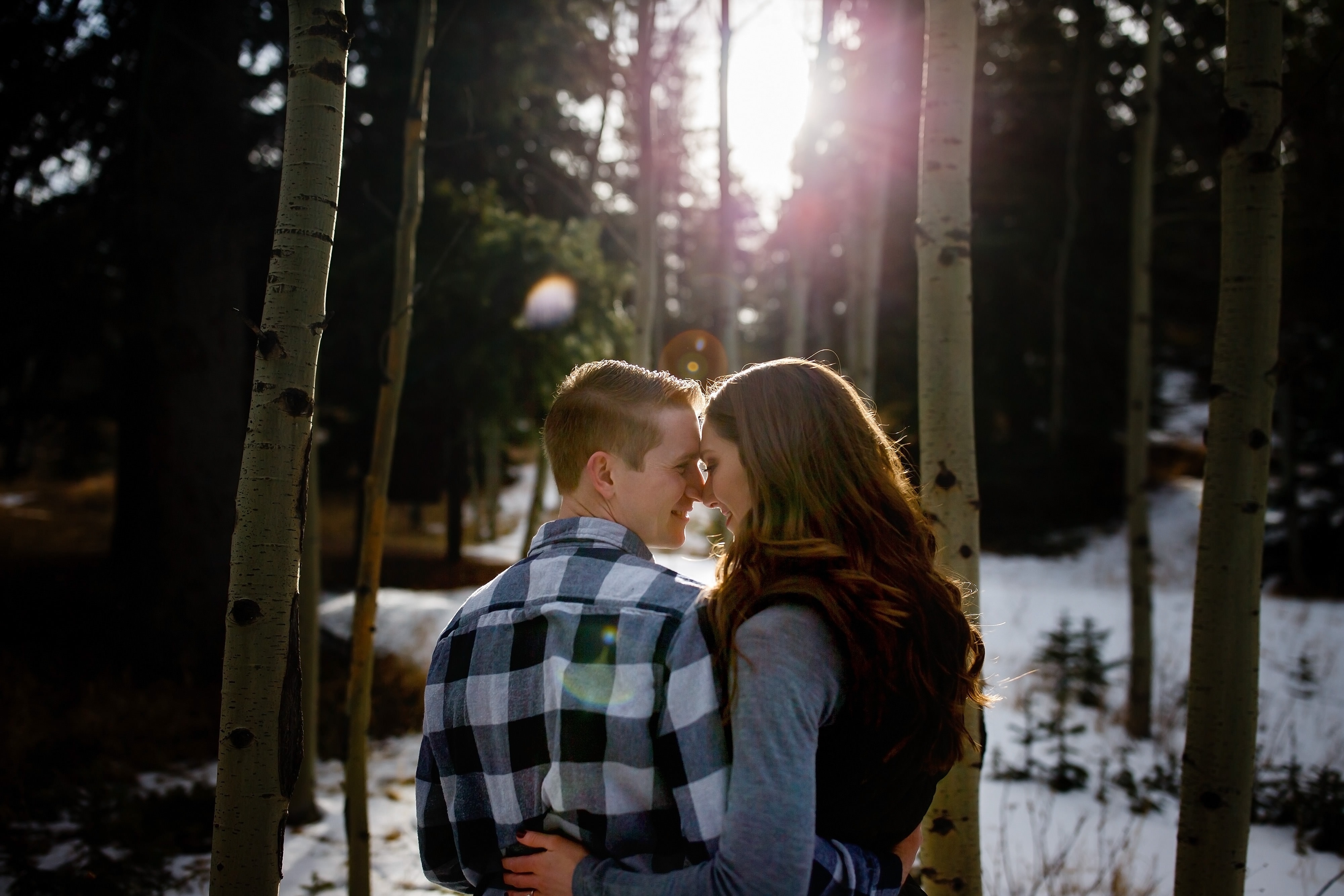 A couple pose together during their winter evergreen engagement session