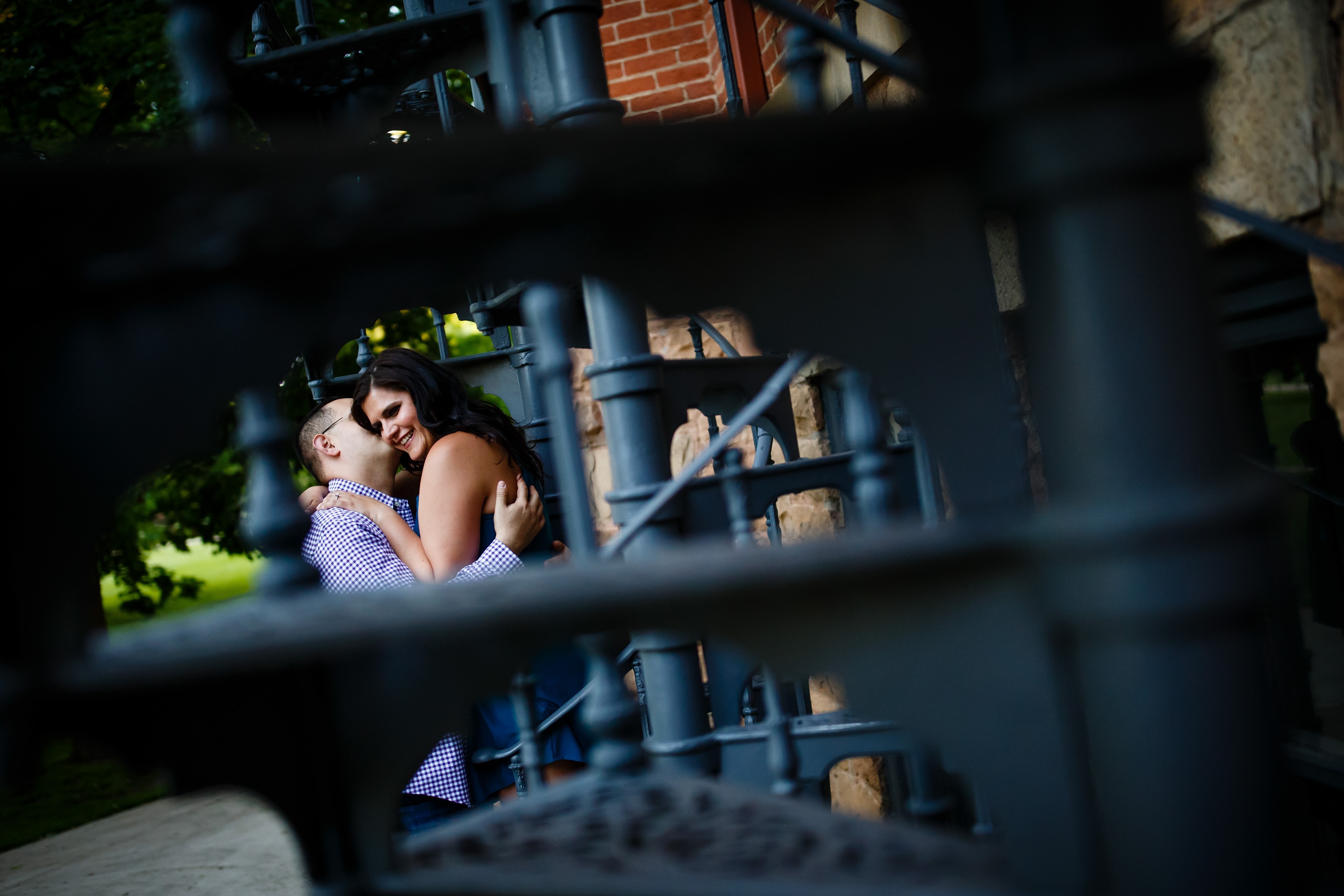 George kisses Dimitra during their Boulder engagement photos near Old Main Chapel
