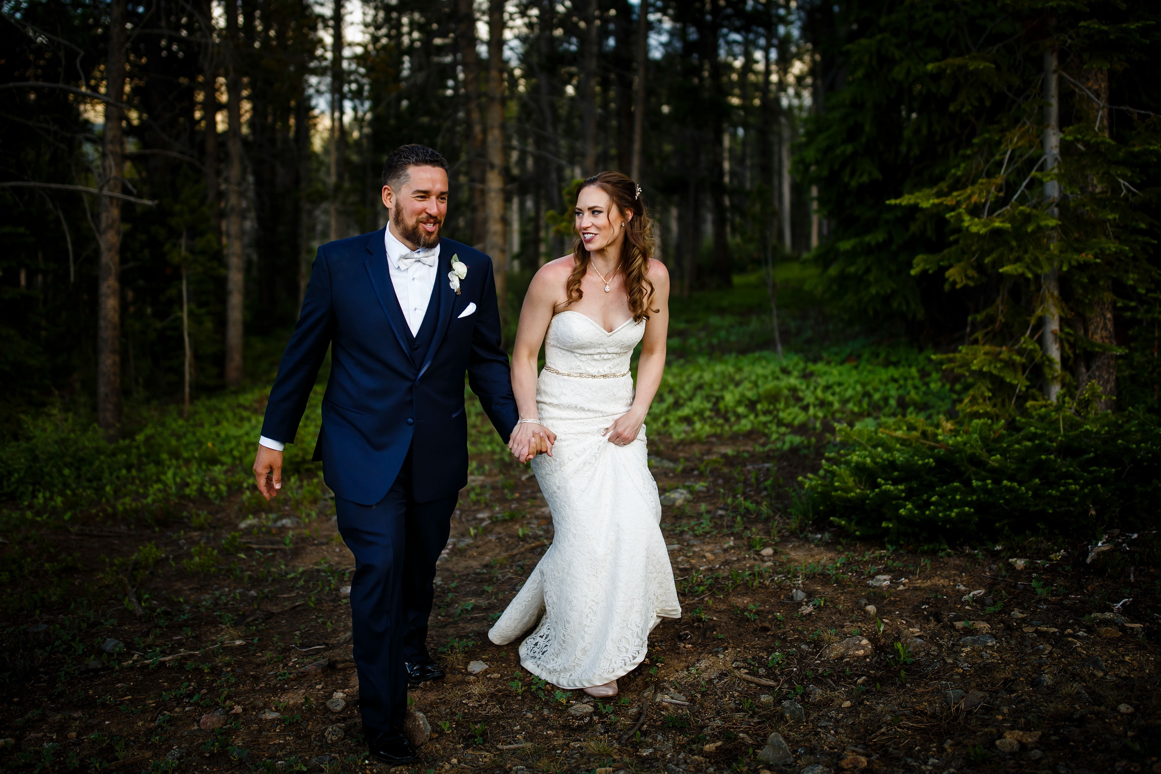 Nick and Sharon walk out of the woods together during their TenMile Station wedding in Breckenridge