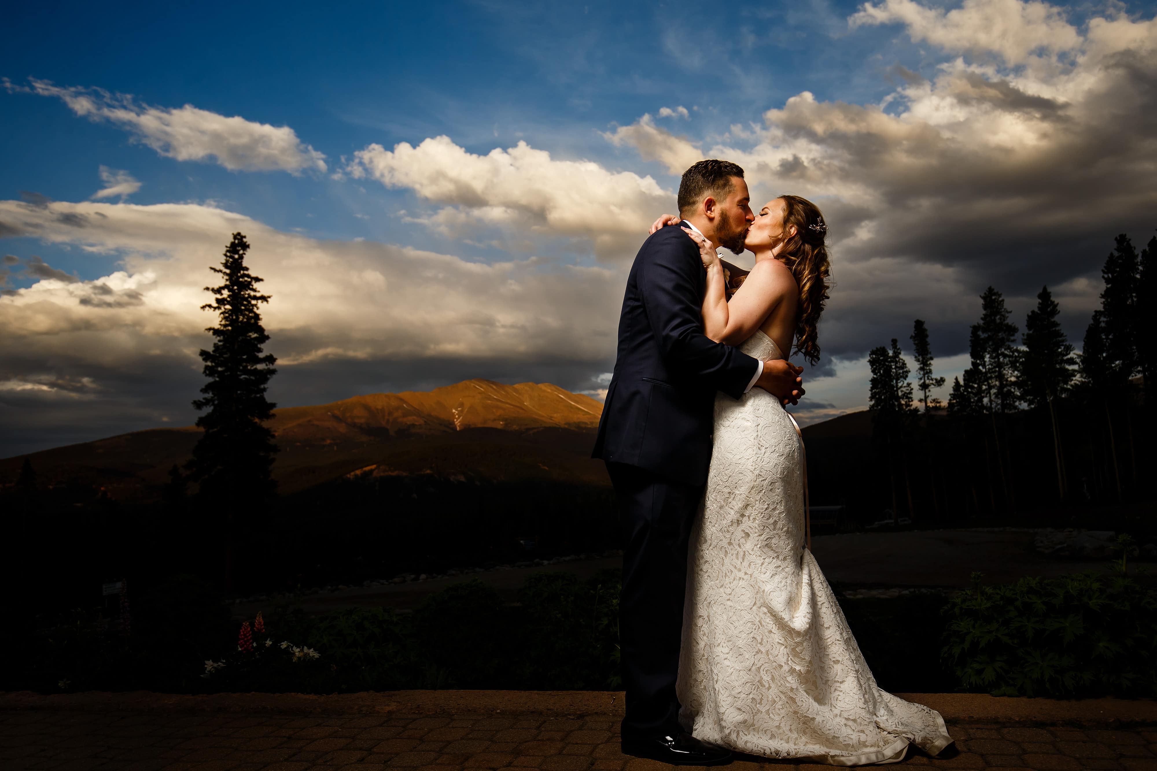 Nick and Sharon kiss and pose for a photo during sunset at TenMIle Station during their Breckenridge wedding
