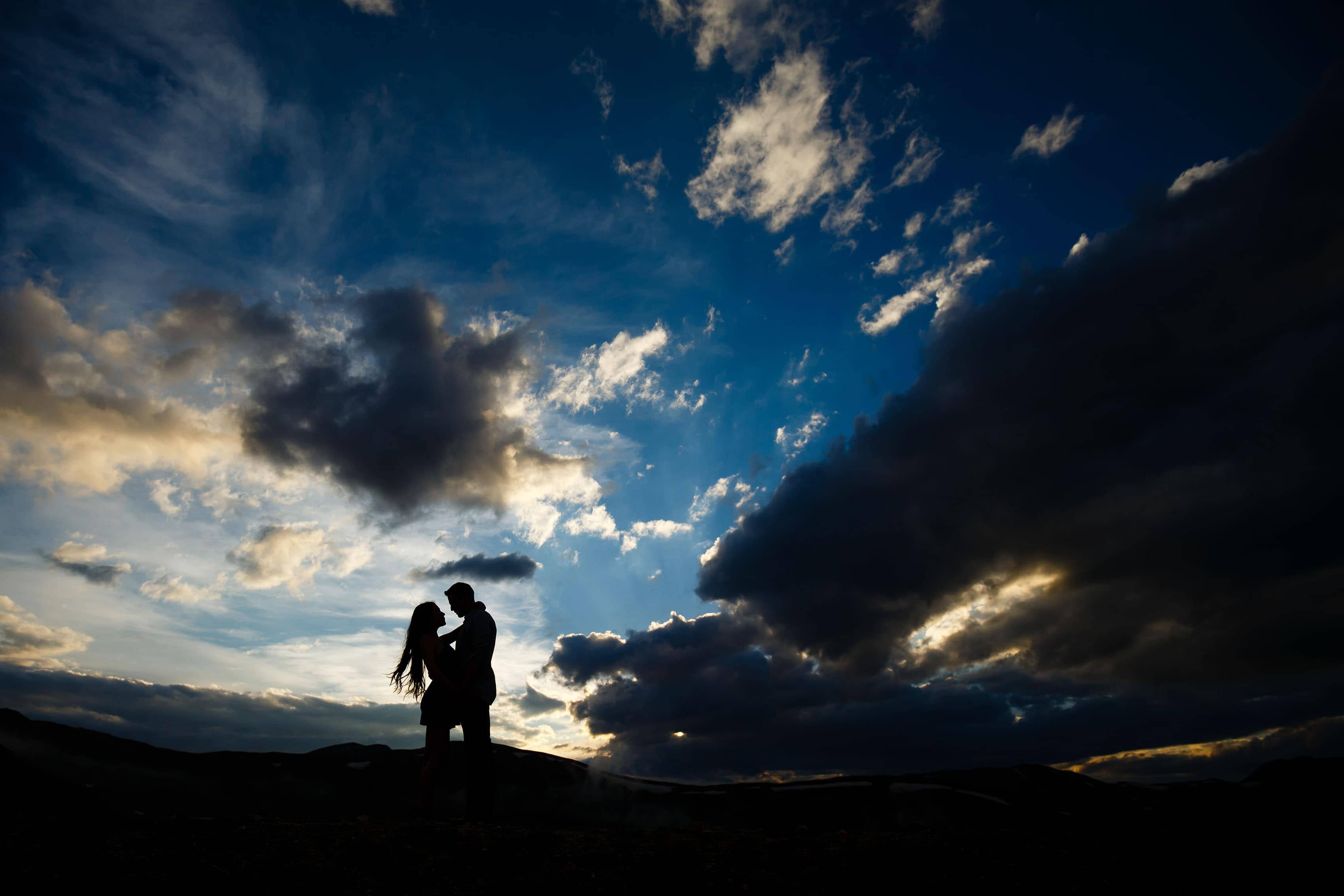 A couple is silhouetted against the sky on Loveland Pass