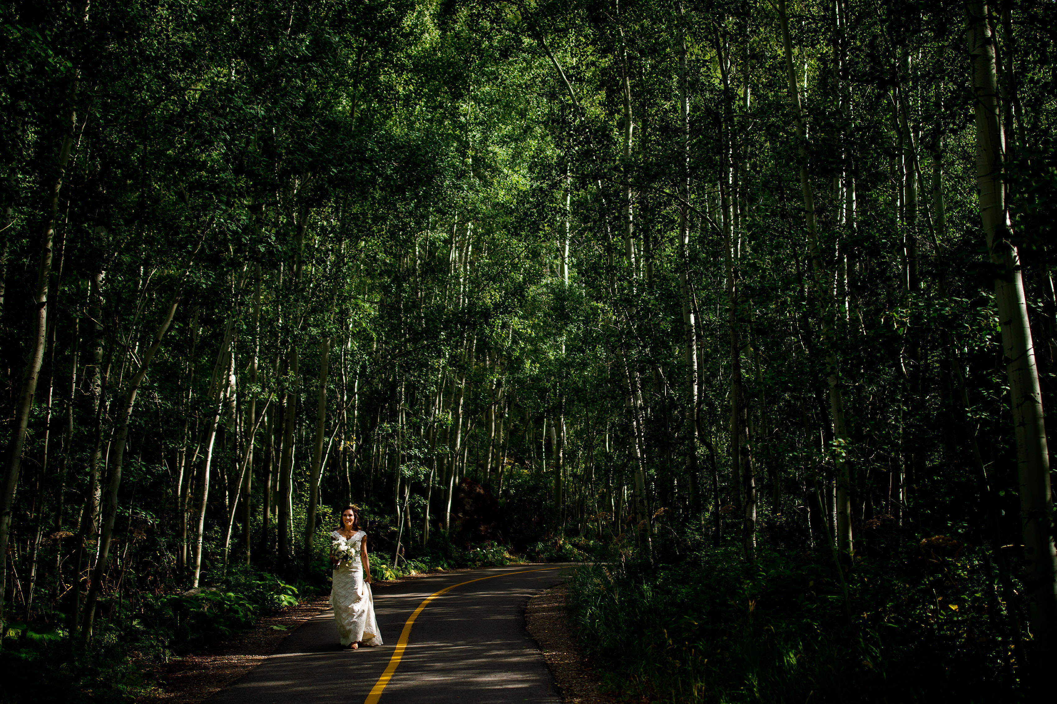 A bride walks through the aspens before her Vail Golf Club wedding