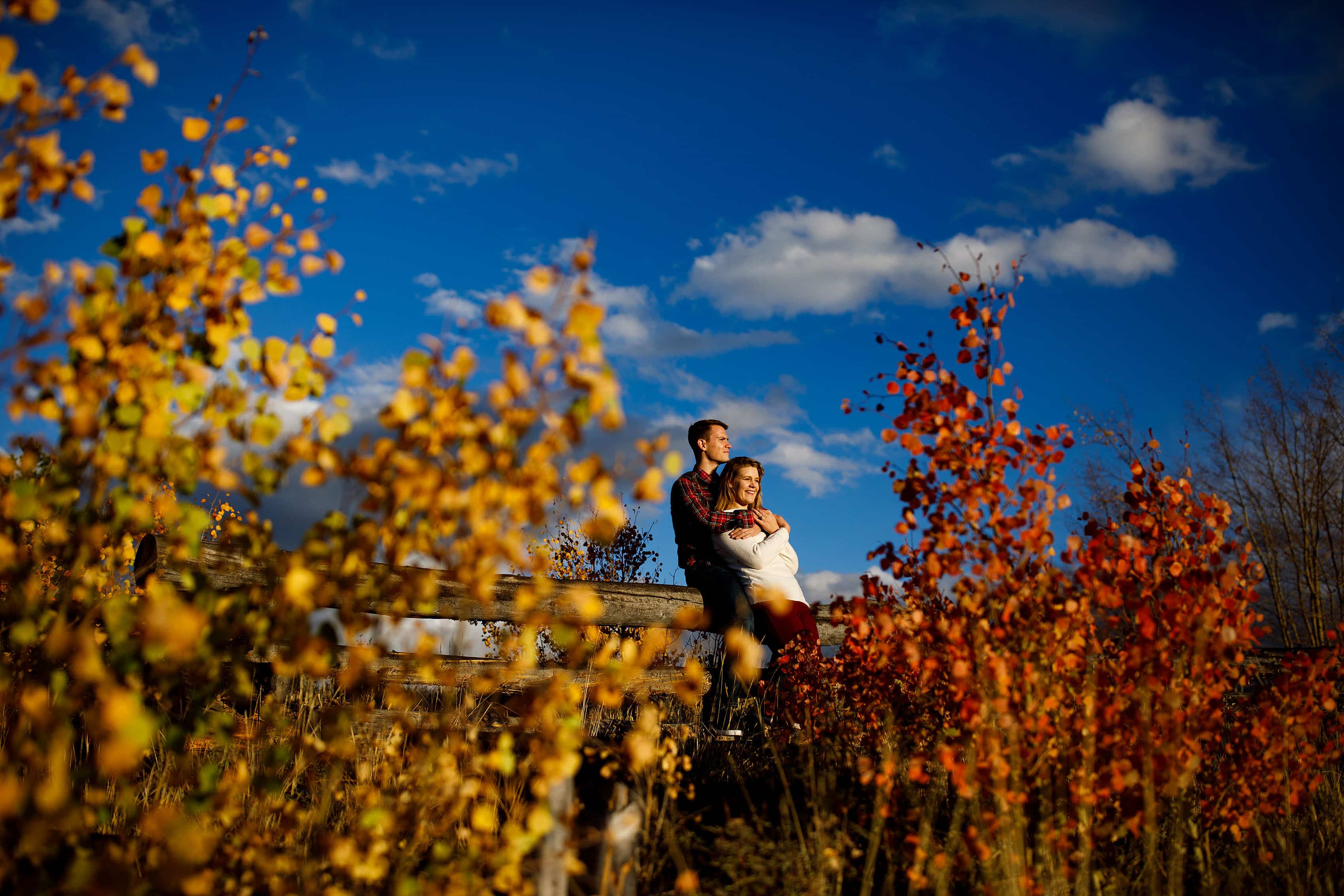 Holly and Hayden are surrpunded by fall color and blue skies during their fall mountain engagement photos