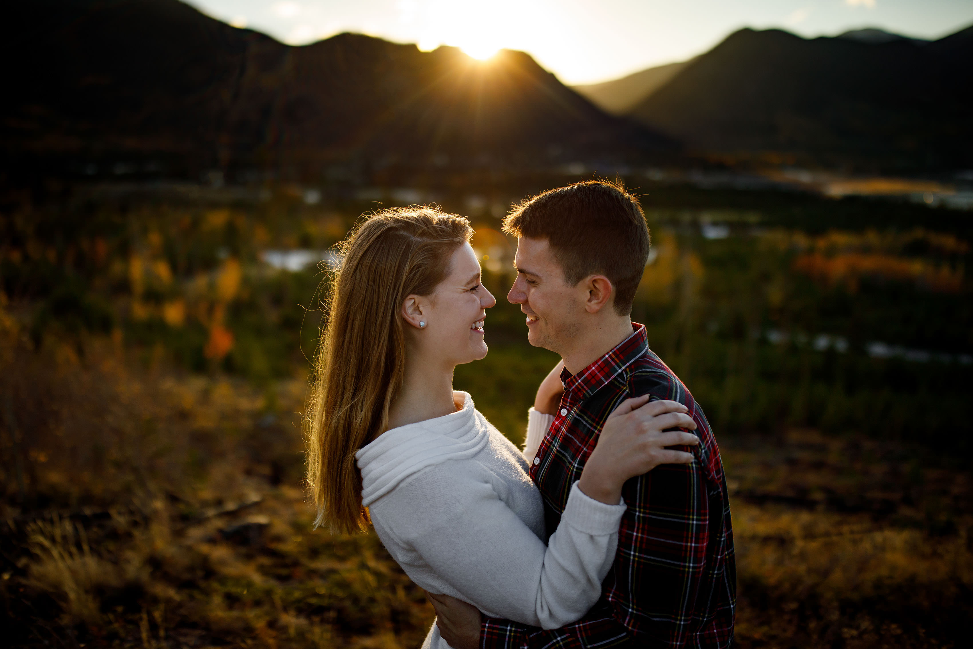 Holly and Hayden smile as the sun goes down during their fall mountain engagement