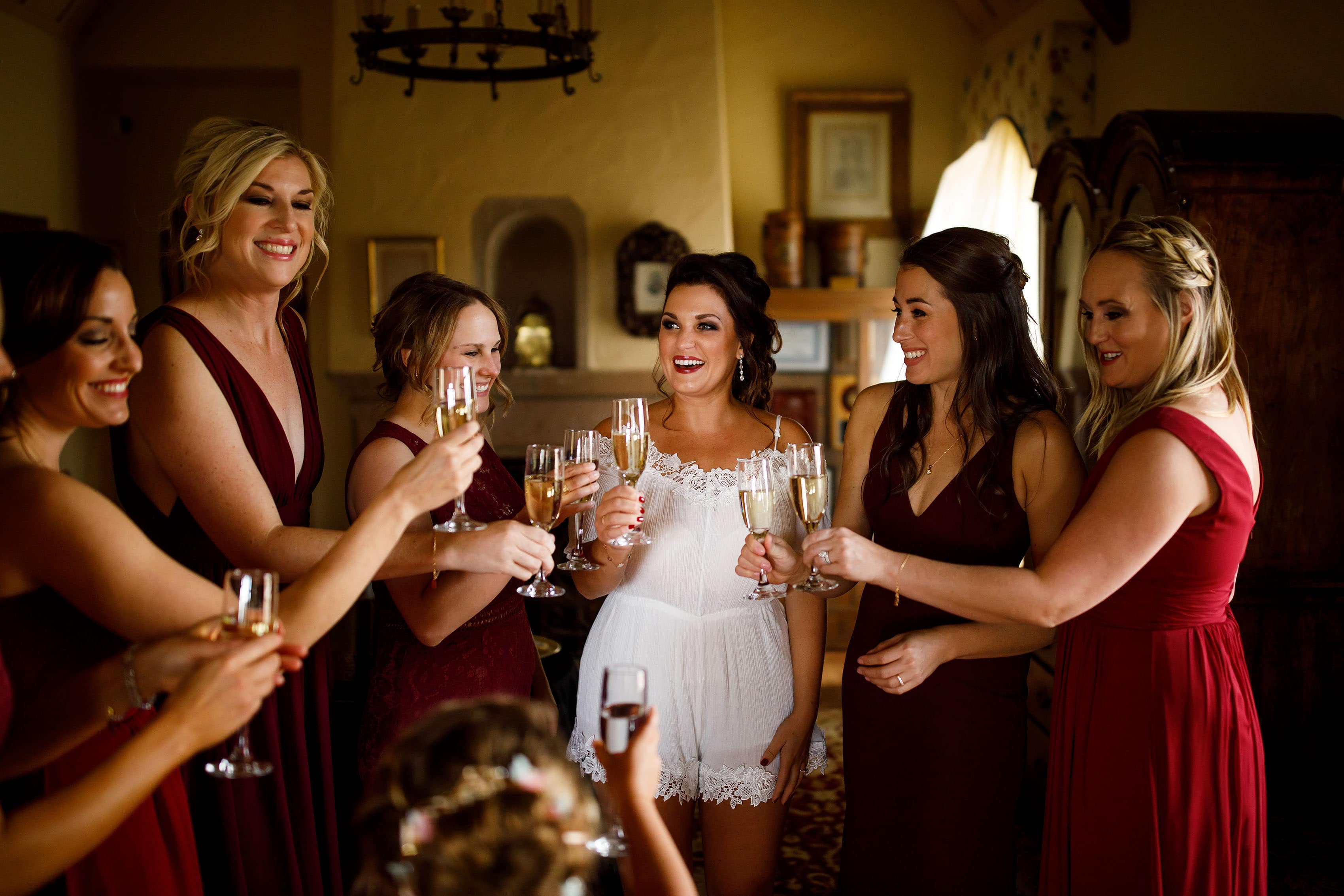 The bride shares a champagne toast with her bridesmaids while getting ready for her Cherokee Ranch & Castle wedding