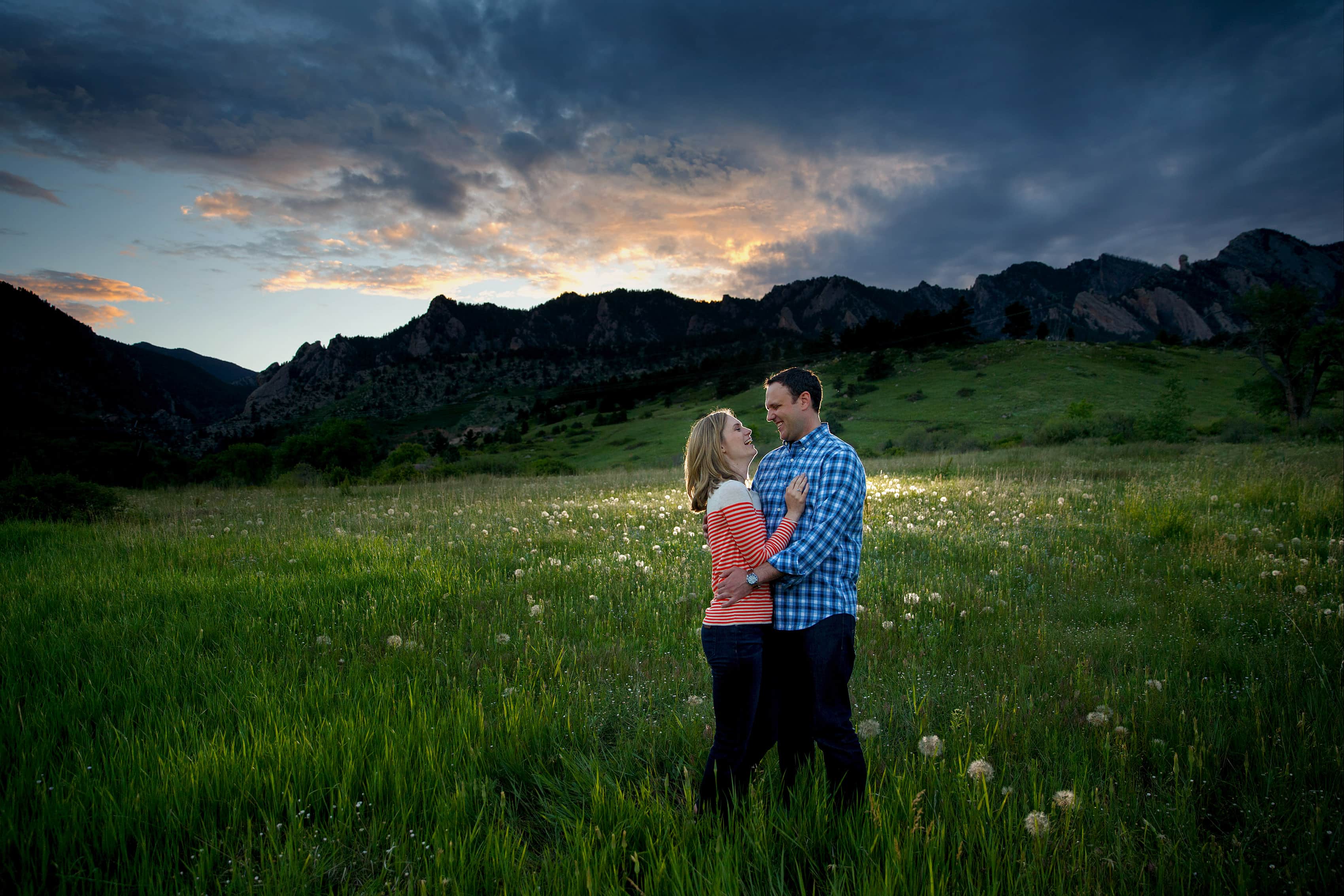 A couple embrace in a meadow at sunset in Eldorado Springs during their engagement session