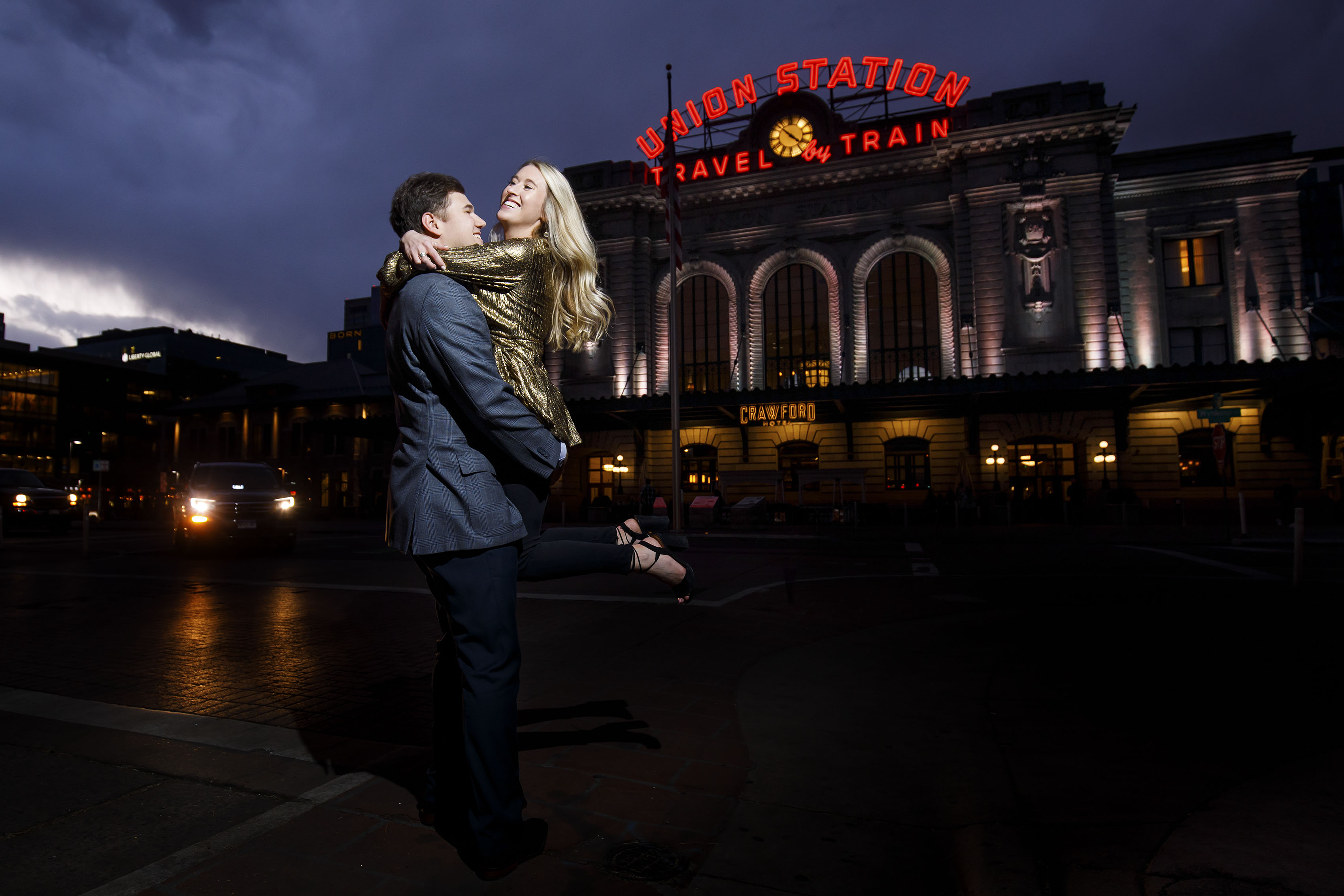 Alex picks up Sierra as they celbrate after Alex proposed outside Denver's Union Station