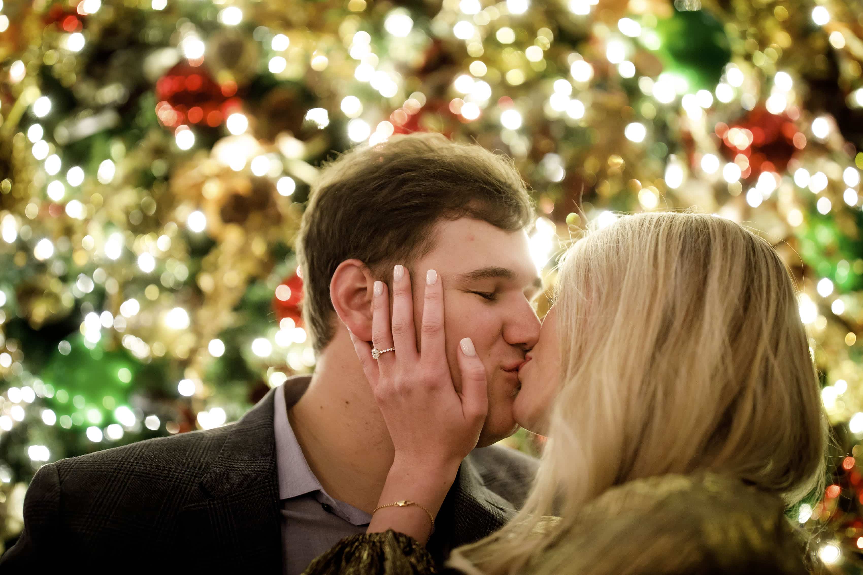 Sierra and Alex share a kiss near the Christmas tree inside Union Station after Alex proposed in Denver