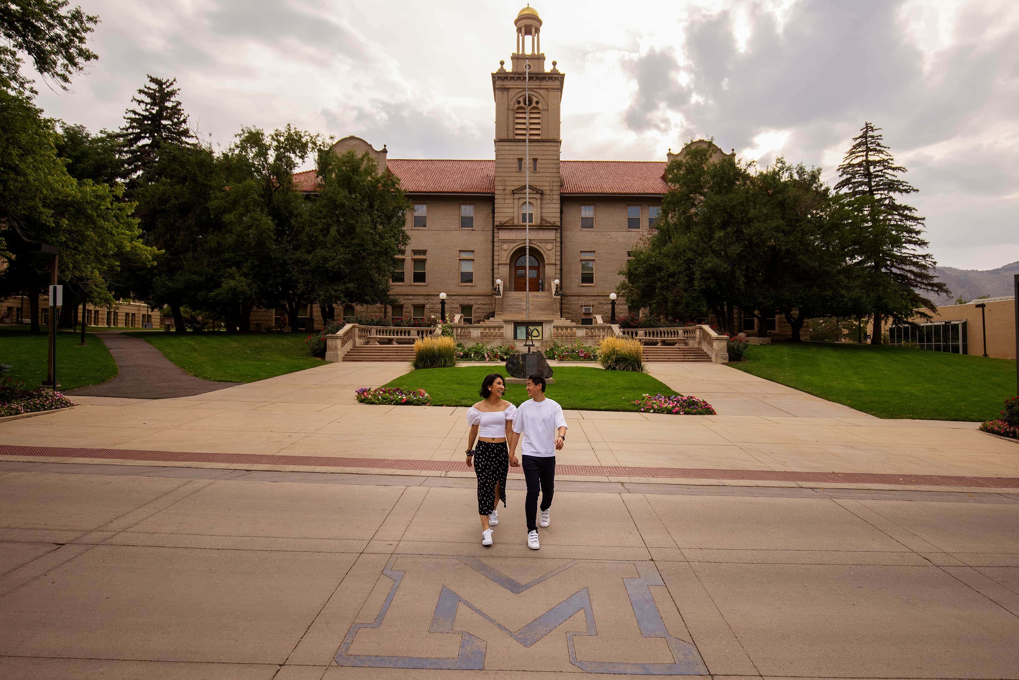 A couple walks together at Colorado School of Mines during their engagement session