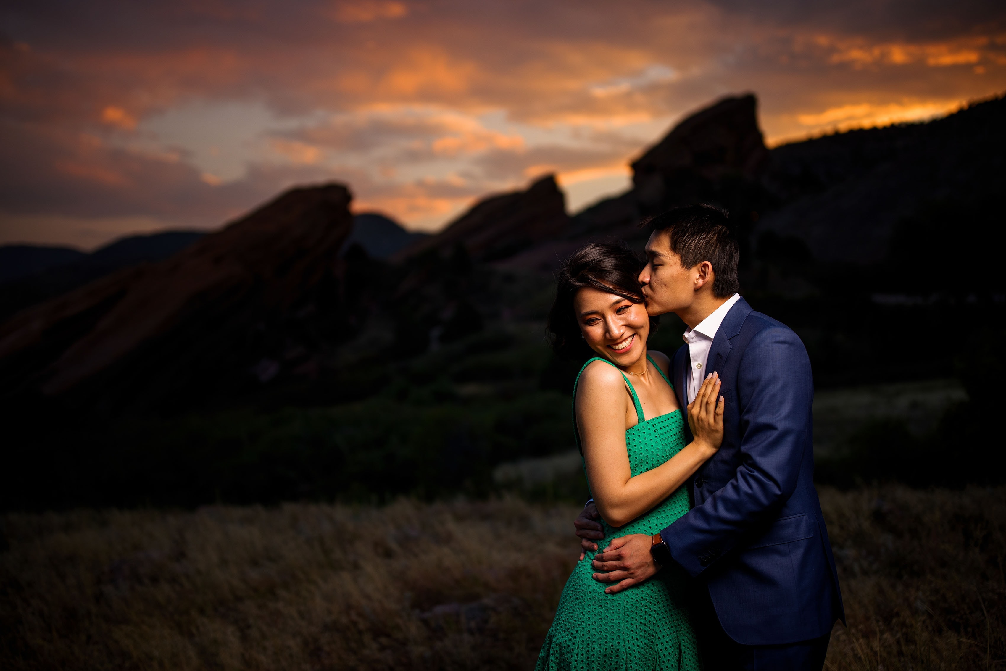 The sun sets over Red Rocks amphitheatre as Sunny kisses Yufan during their engagement session