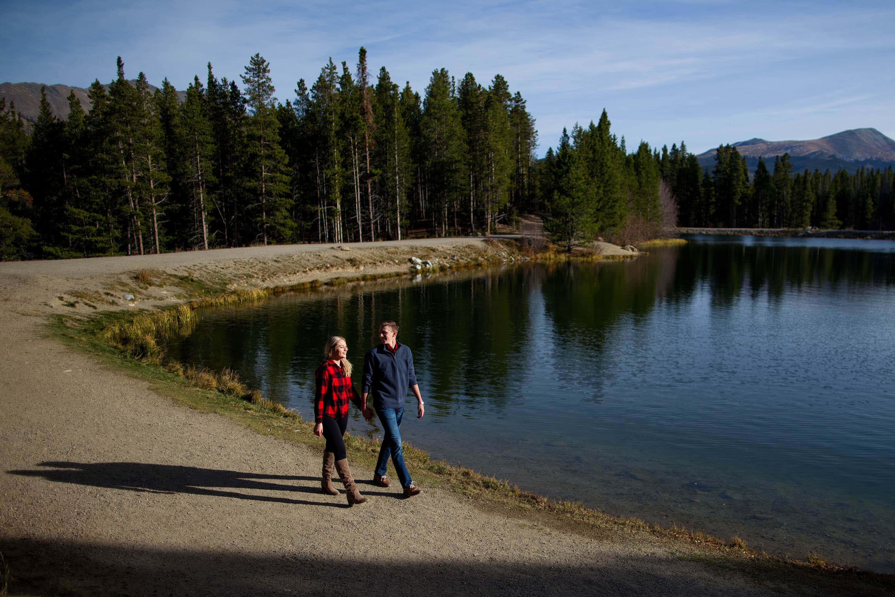 Chloe and Joseph walk along the waterÕs edge at Sawmill Reservoir during their Breckenridge engagement