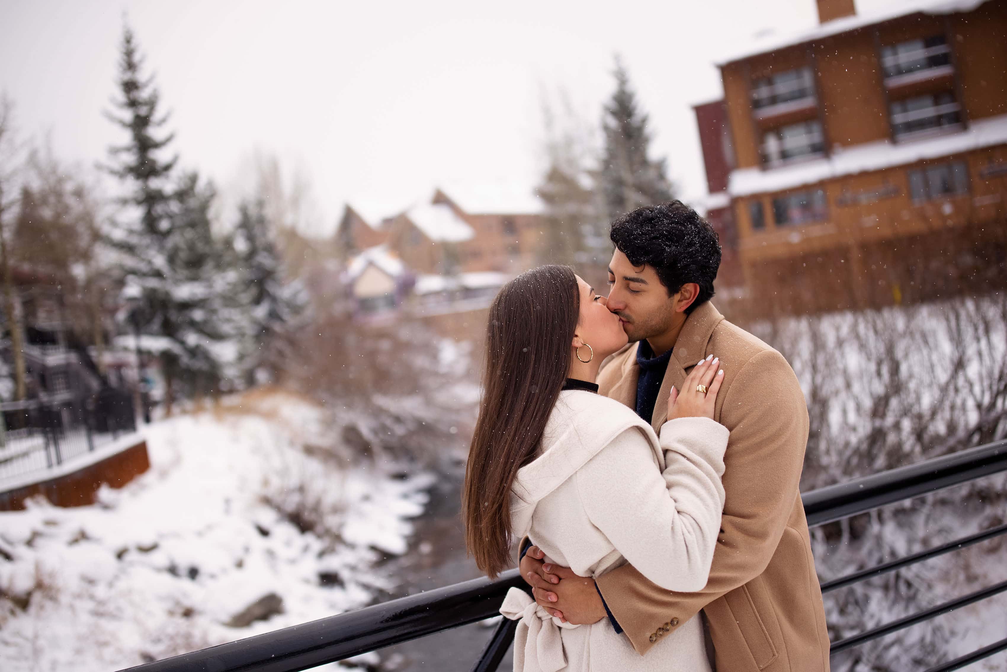 Kooper and Raul share a kiss on a bridge in Breckenridge during their engagement photos