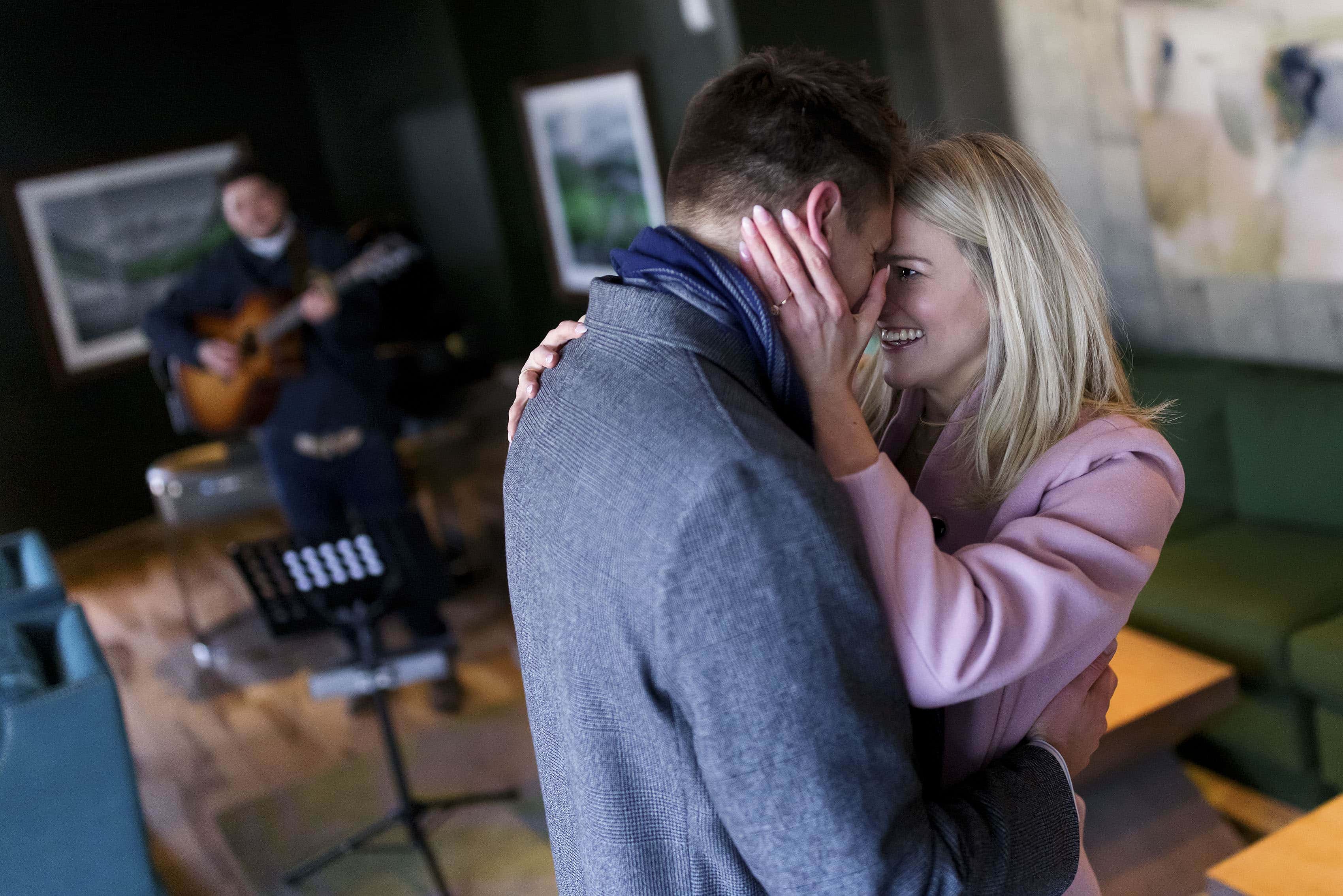 The couple dances together as an acoustic guitarist plays a song after the marriage proposal